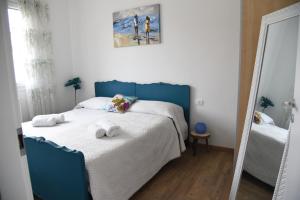 una camera da letto con un letto blu e asciugamani di Cozy 5 people Apartament a Mogliano Veneto