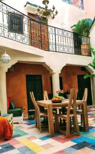 ein Esszimmer mit einem Tisch und Stühlen sowie einem Balkon in der Unterkunft Riad BILKIS in Marrakesch