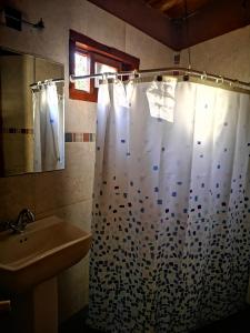 a bathroom with a shower curtain and a sink at Hostal Elim in San Pedro de Atacama +36 photos