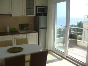 a kitchen with a table and a view of the ocean at Apartments Holiday in Split