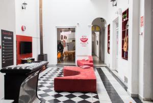 una habitación con 2 sofás rojos y una mesa en Student’s Hostel, en Montevideo