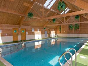 a large swimming pool in a large building at 92 Barmouth Bay Holiday Park in Llanddwywe