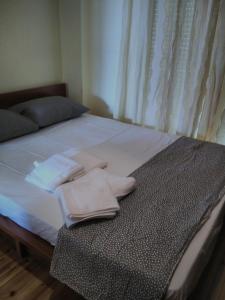 a bed with two towels sitting on top of it at Cozy Penthouse in Thessaloniki