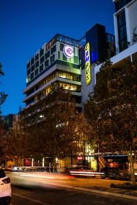 a tall building with a sign on it at night at Hostel G Perth in Perth