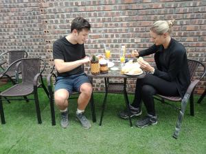 un hombre y una mujer sentados en una mesa comiendo comida en Khai Yen Tam Coc Hostel en Ninh Binh