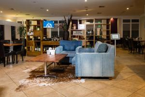 a lobby with two blue chairs and a coffee table at Wattle Grove Motel in Perth