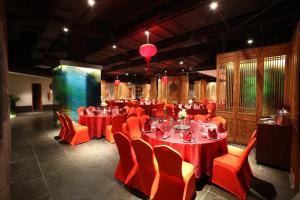 a banquet hall with red tables and orange chairs at Mangrove Tree Resort World Sanya Bay-Coconut in Sanya