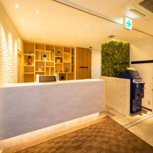 a cashier counter in a lobby with a pay phone at Super Hotel Towada Natural Hot Springs in Towada