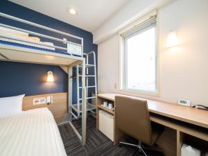um quarto com uma cama, uma secretária e um beliche em Super Hotel Towada Natural Hot Springs em Towada