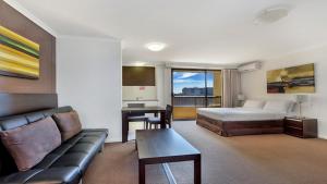 a hotel room with a bed and a couch at In the City Studio at College St in Sydney