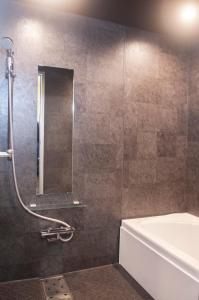 a bathroom with a shower with a tub and a sink at Dear Place(Adult Only) in Osaka