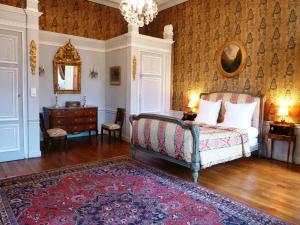 a bedroom with a bed and a table and a mirror at Château de Saint-Augustin in Château-sur-Allier