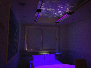 a purple room with a couch and purple lights at Dear Place(Adult Only) in Osaka
