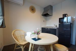 a small kitchen with a small white table and chairs at KYOSTAY Iroha Toji Main in Kyoto