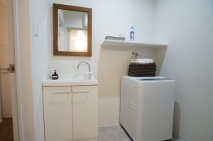 a white bathroom with a sink and a mirror at KYOSTAY Iroha Toji Main in Kyoto