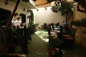 an empty patio with tables and chairs and plants at Hostel Splendido in Šibenik