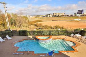 a large swimming pool in the middle of a field at Sleep Inn & Suites University in Abilene