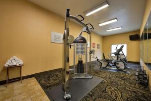 a gym with a treadmill and two exercise bikes at Comfort Suites Bay City in Bay City