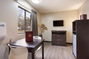 a room with a table and a kitchen with a television at Econo Lodge Olathe - Kansas City in Olathe