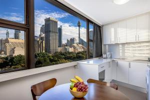 a kitchen with a table with a bowl of fruit on it at Apartment at College St in Sydney