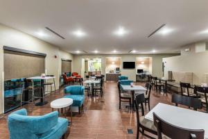沃思堡Sleep Inn & Suites Fort Worth - Fossil Creek的一间设有桌子和蓝色椅子及桌上电脑的用餐室