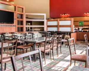 a dining room with tables and chairs and a tv at Comfort Inn & Suites and Conference Center in Mount Pleasant