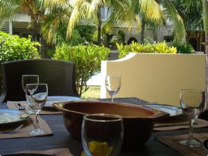 a table with a bowl and wine glasses on it at Althea's nice, comfy 4 BR townhouse with pool in Grand Bay- AH 1 in Grand Baie