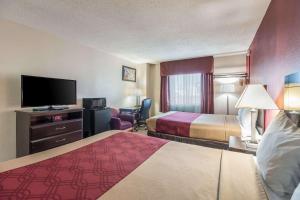 a hotel room with two beds and a flat screen tv at Econo Lodge in Lexington