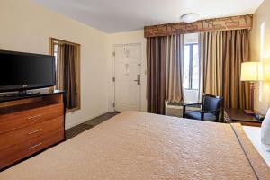 a hotel room with a bed, television and a desk at Rodeway Inn at Nevada State Capitol Carson City in Carson City
