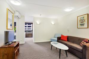 a living room with a couch and a tv at City apartment at College St in Sydney