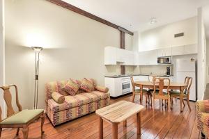 a living room with a couch and a table and chairs at Apartment Harborside Comfort in Sydney
