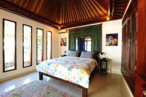 1 dormitorio con 1 cama en una habitación con ventanas en Villa Bulan Mas, en Ubud
