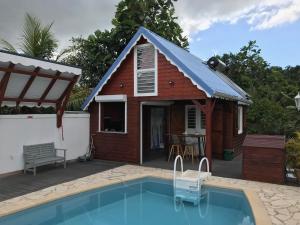 uma pequena casa com uma piscina em frente em Iguane Rouge em Petit-Bourg