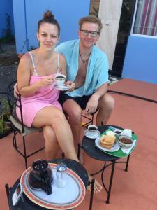 Ein Mann und eine Frau sitzen auf Stühlen und trinken Kaffee. in der Unterkunft Bob Apartments in Calodyne