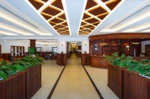 a large hall with wooden partitions with plants at City River Hotel in Siem Reap