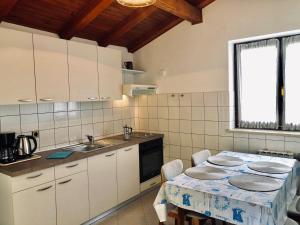 a kitchen with a table and a sink at Apartments Petricic with swimming pool in Ičići