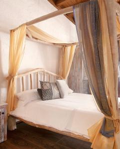 The Iskemleci Guest House في Lefkosa Turk: غرفة نوم بها سرير مظلة مع وسائد عليها