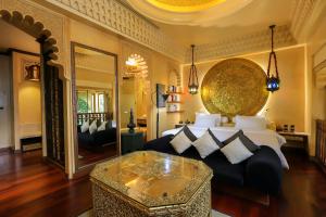 a bedroom with a large bed and a table at Sawasdee Village in Kata Beach