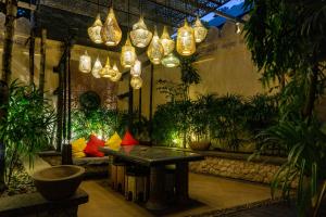 a room with a table and potted plants and lights at Sawasdee Village in Kata Beach