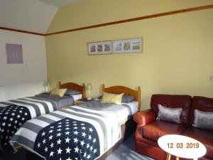 una habitación con dos camas y un sofá en Kindale House, en Helmsdale 5 fotos más