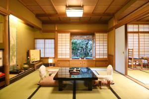 um quarto com uma mesa e cadeiras e uma janela em Seikoro Ryokan - Established in 1831 em Quioto