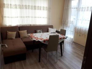 ein Wohnzimmer mit einem Tisch und einem Sofa in der Unterkunft Apart Magic in Kardschali