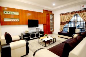 a living room with a couch and a tv at Decozy 3.0 Semi-D in Ipoh