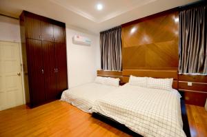 a bedroom with a large bed with a wooden headboard at Decozy 3.0 Semi-D in Ipoh