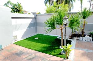 a small garden with green grass and a lamp at Decozy 3.0 Semi-D in Ipoh