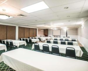 una sala de conferencias con mesas y sillas blancas y una pantalla en Econo Lodge Inn & Suites Shamokin Dam - Selinsgrove, en Shamokin Dam