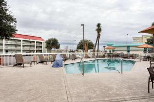 a swimming pool at a resort with tables and chairs at Quality Inn Gulfport I-10 in Gulfport