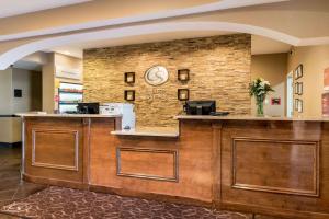 a lobby with a waiting area with a clock on a brick wall at Comfort Suites Atlantic City North in Absecon
