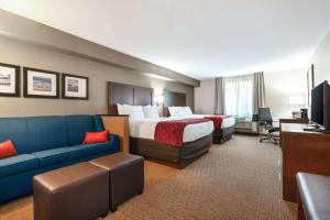 a hotel room with two beds and a couch at Comfort Suites Atlantic City North in Absecon