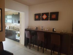 a kitchen with a large black bar with chairs at VillaRenoma in Nadarzyn